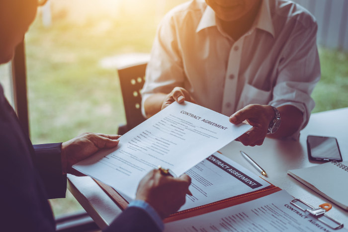 Two people reviewing contract agreement