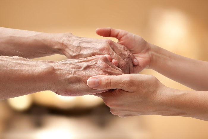 Elderly and young hands holding eachother